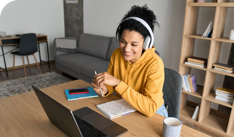 female student sitting on desk attending a call